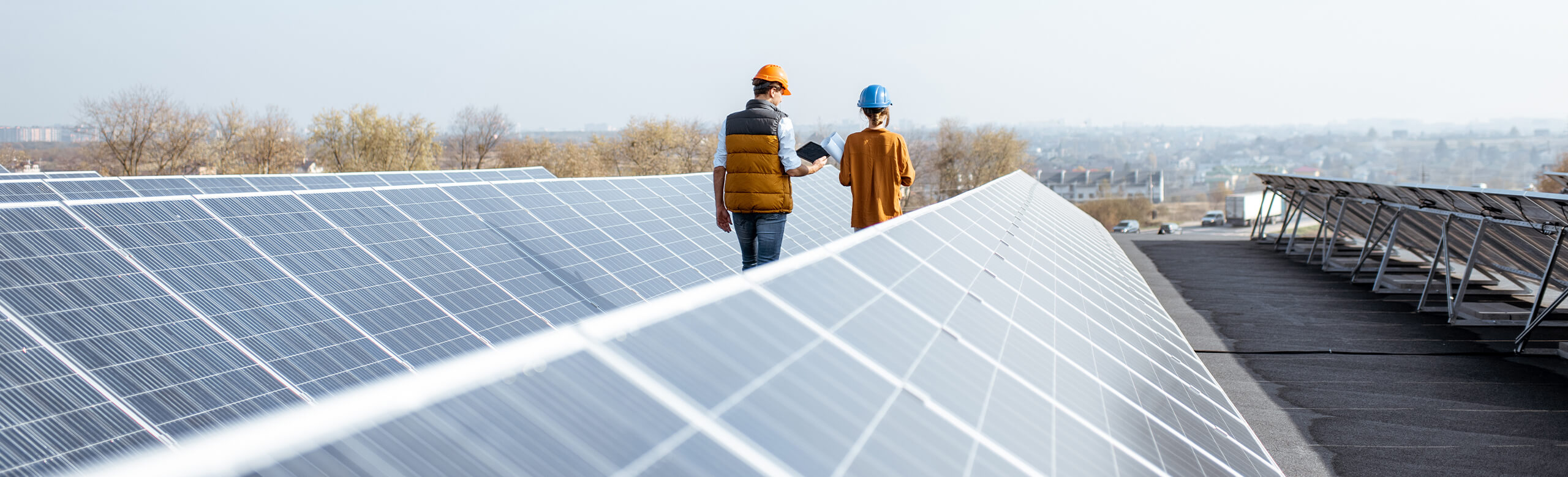 Individuals walking along a roof featuring solar panel installations and REGUPOL solar.